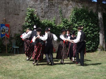 Die ansonsten in dezentem Schwarz gehaltene Tracht der Volkstanzgruppe Ulten besticht vor allem durch ihre Schürzen mit rot leuchtenden Blumenmustern.